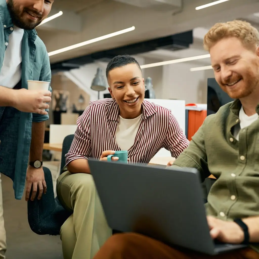 Colleagues collaborating on laptops in a modern office, representing a lean venture-backed team managing global expansion