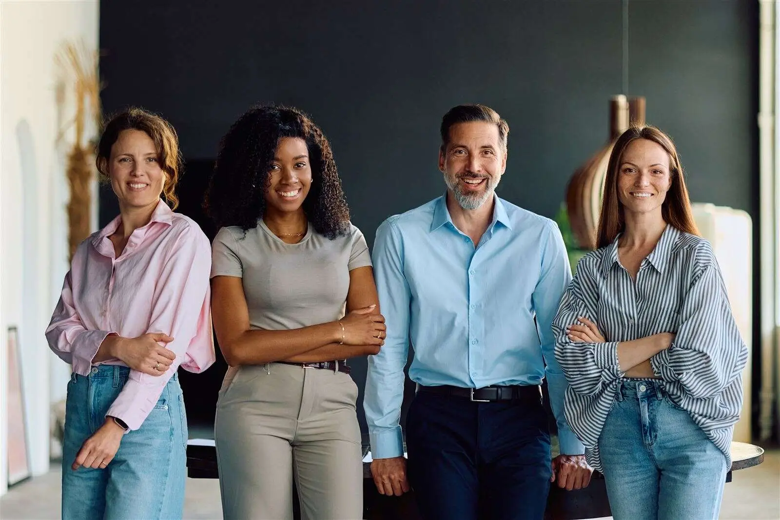 Four business professionals standing together in an office